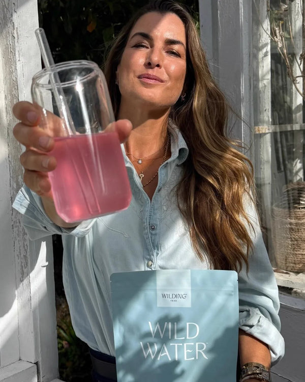Fee Drummond raising a glass of WILD WATER™ and holding the pouch